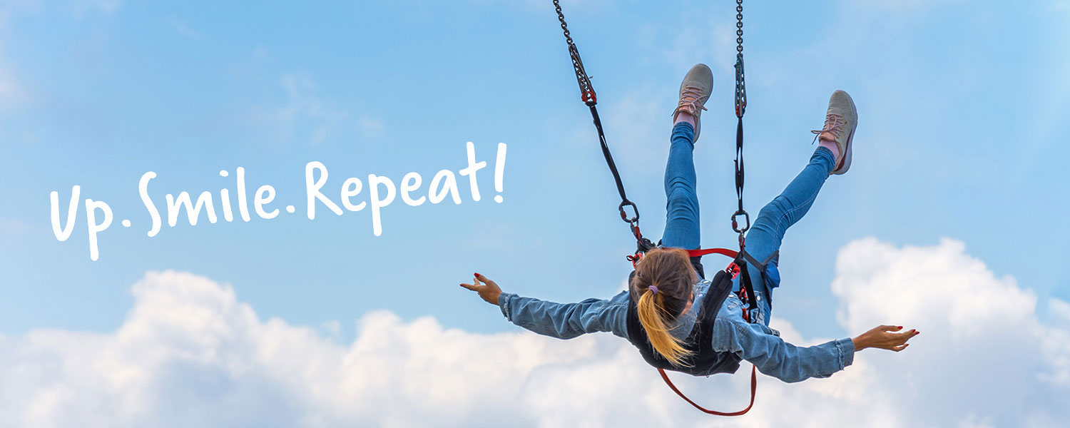 Junges M�dchen schwingt in einem Sicherheitsgurt Richtung Himmel